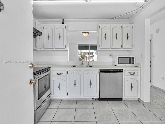 kitchen featuring stainless steel appliances, white cabinetry, sink, and a textured ceiling