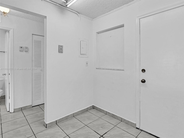 interior space with a textured ceiling and light tile patterned floors