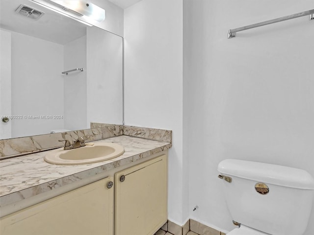 bathroom featuring toilet, vanity, and tile patterned floors