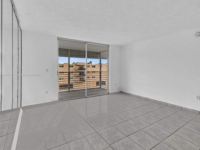 spare room with expansive windows and a textured ceiling