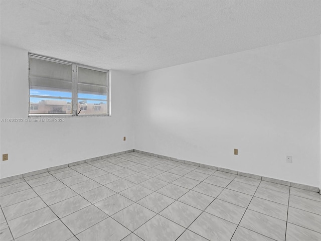 unfurnished room featuring a textured ceiling