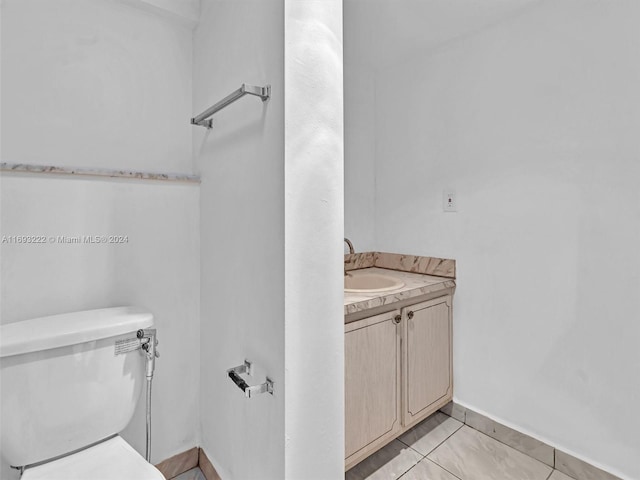 bathroom with tile patterned flooring, vanity, and toilet