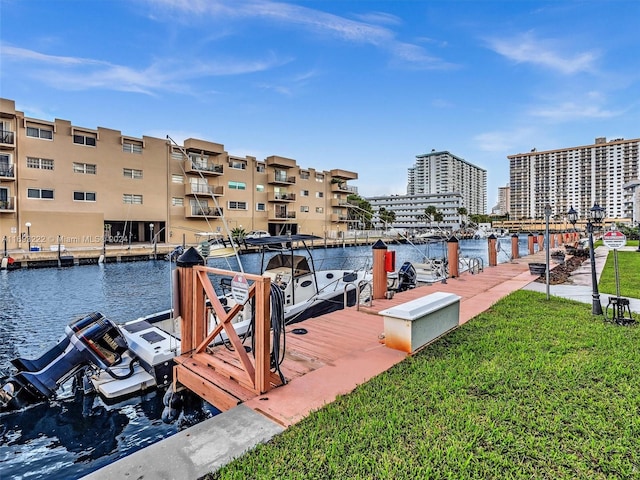 view of dock with a water view and a yard