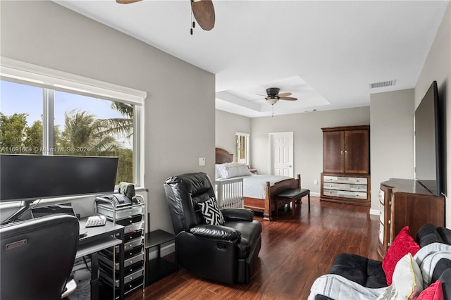 interior space with ceiling fan, a raised ceiling, and dark hardwood / wood-style flooring