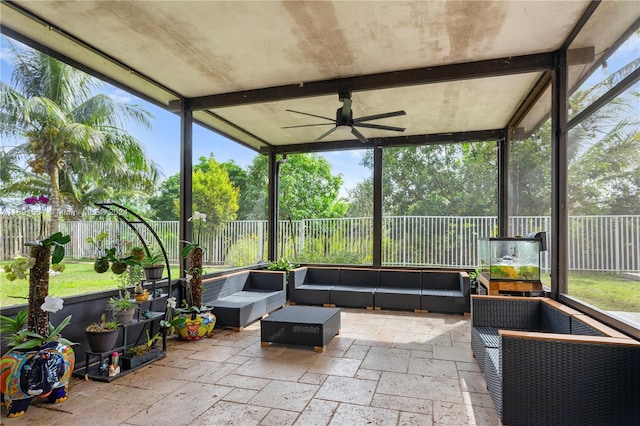 sunroom / solarium featuring beamed ceiling and ceiling fan