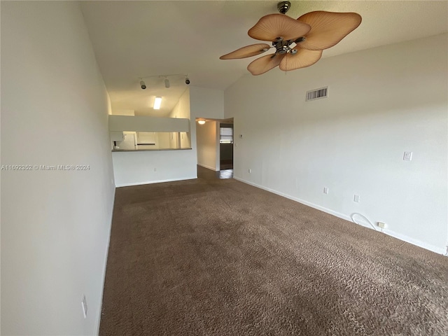 unfurnished living room featuring rail lighting, high vaulted ceiling, ceiling fan, and dark carpet