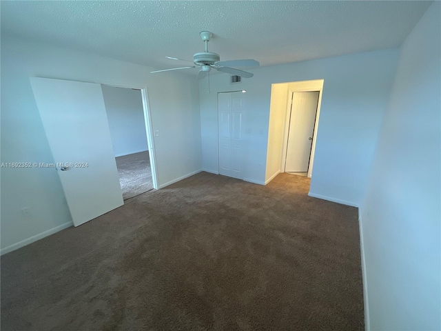 carpeted spare room with a textured ceiling and ceiling fan