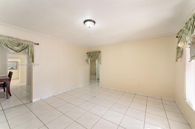 spare room with light tile patterned floors and crown molding