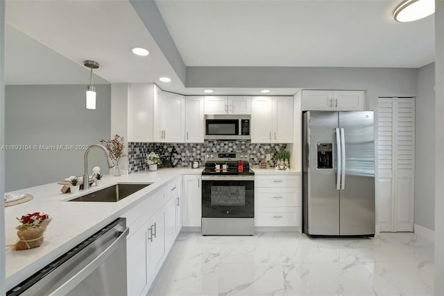 kitchen featuring sink, appliances with stainless steel finishes, white cabinetry, tasteful backsplash, and decorative light fixtures