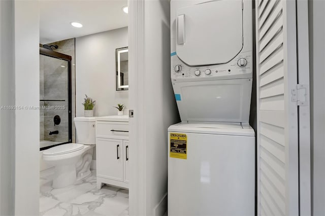 interior space with shower / bath combination with glass door, vanity, toilet, marble finish floor, and stacked washing maching and dryer