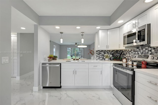 kitchen with white cabinetry, sink, decorative backsplash, hanging light fixtures, and stainless steel appliances