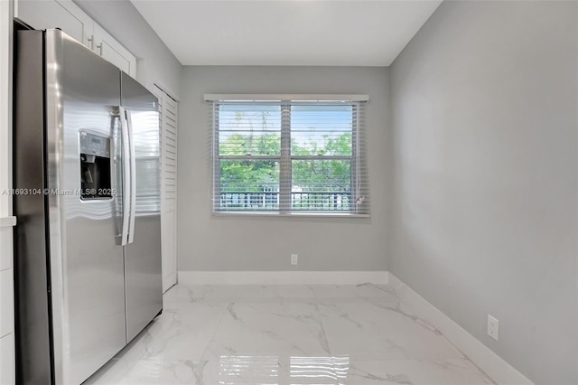interior space with baseboards and marble finish floor