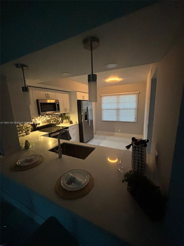 kitchen featuring a sink, white cabinets, appliances with stainless steel finishes, and decorative backsplash