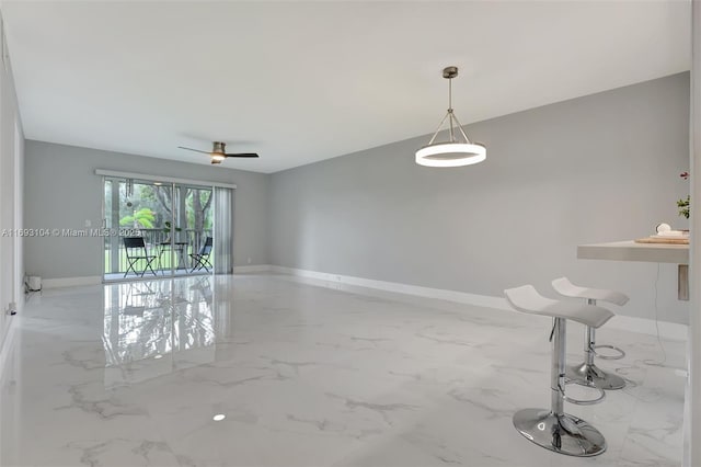 unfurnished living room with baseboards, marble finish floor, and ceiling fan