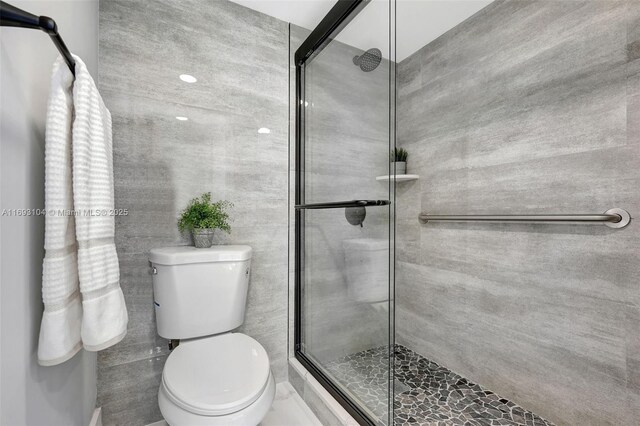 bathroom featuring toilet and a shower stall