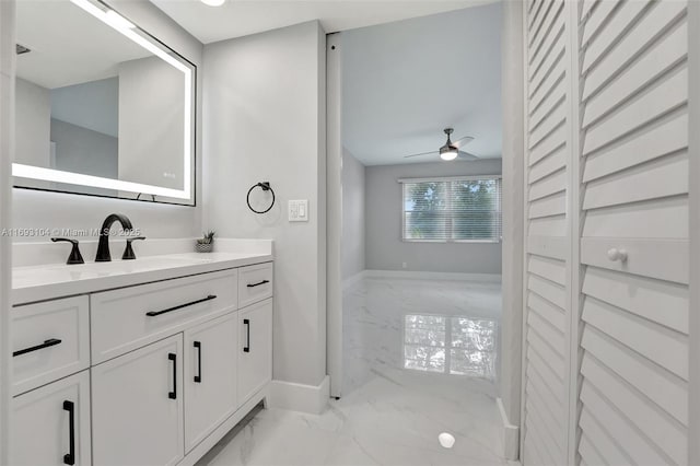 bathroom with baseboards, marble finish floor, ceiling fan, and vanity