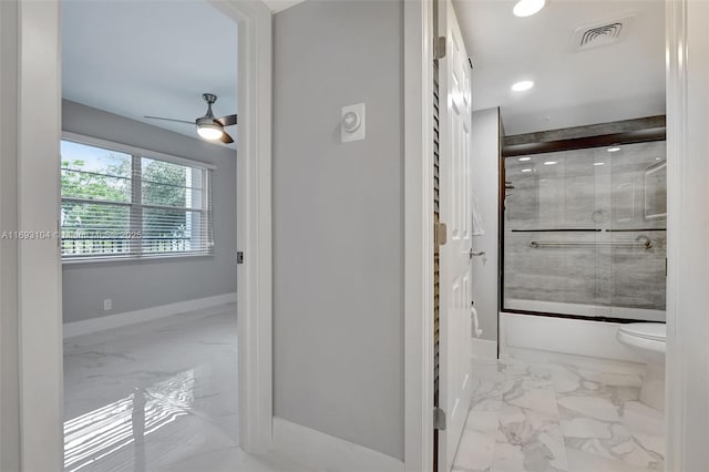 bathroom featuring toilet, ceiling fan, and shower / bath combination with glass door