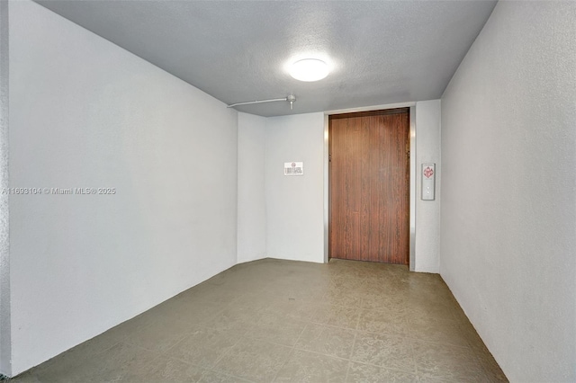 unfurnished room featuring a textured ceiling