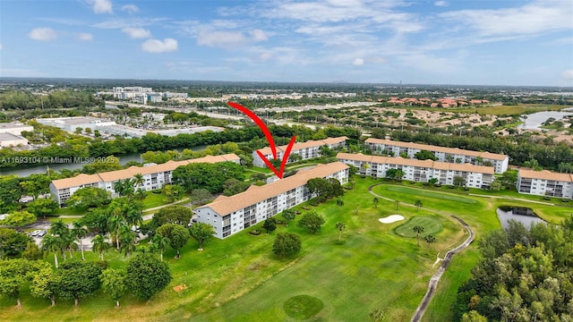 drone / aerial view with a water view and view of golf course