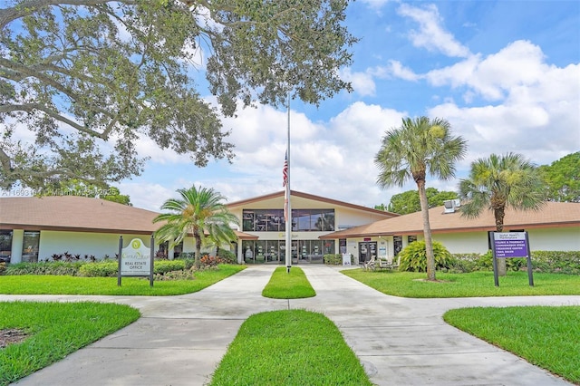 view of property's community featuring concrete driveway and a yard