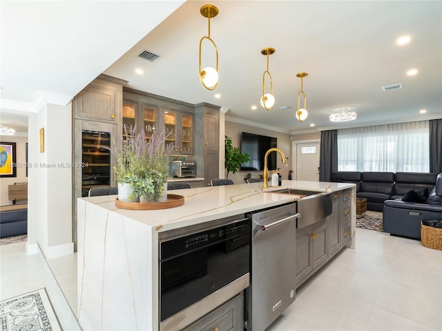 kitchen with sink, light stone counters, ornamental molding, a spacious island, and pendant lighting