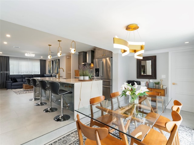 dining space with ornamental molding, a chandelier, and sink