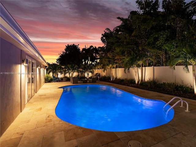 pool at dusk with a patio