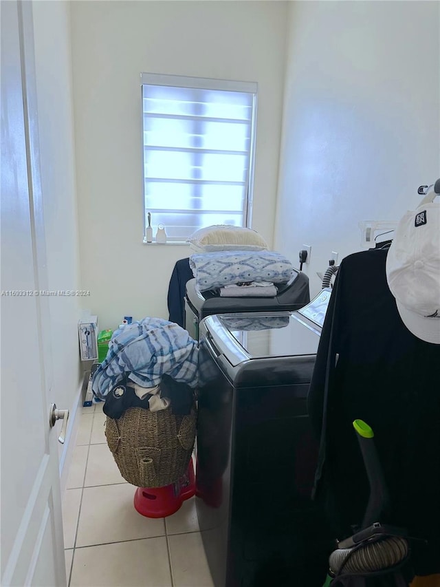 laundry area with washer and dryer and light tile patterned floors