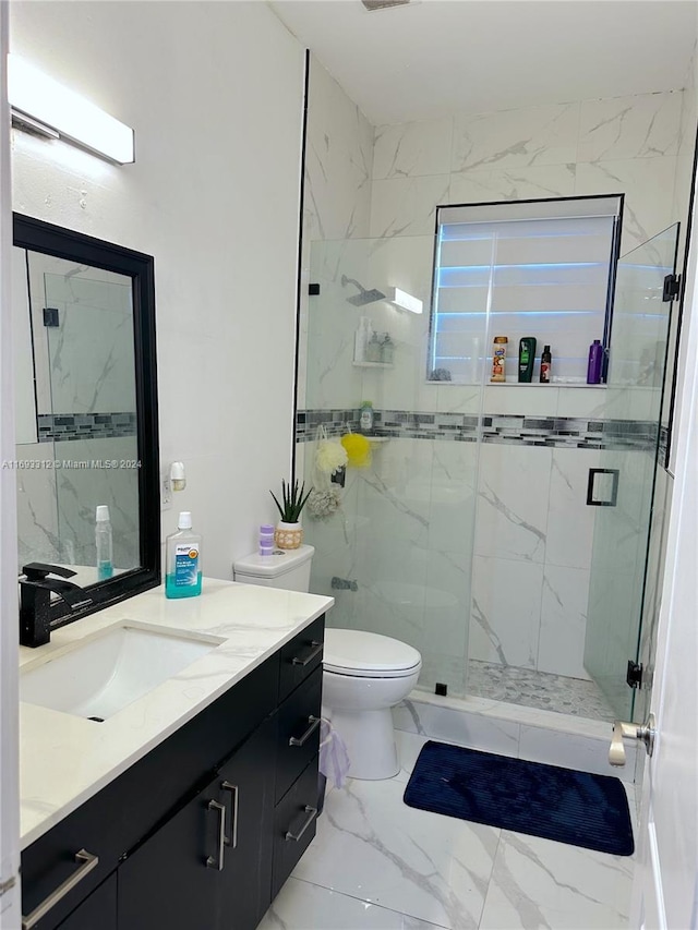 bathroom with a shower with door, vanity, and toilet