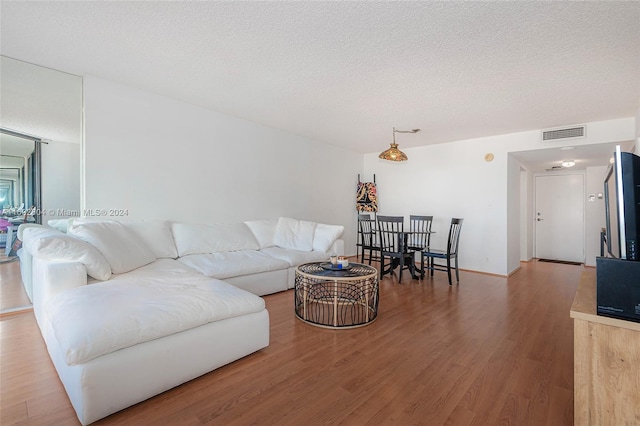 living room with hardwood / wood-style flooring and a textured ceiling