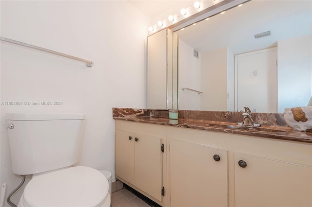 bathroom featuring tile patterned flooring, vanity, and toilet