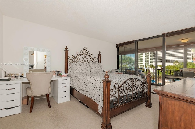 bedroom featuring a textured ceiling, light carpet, and access to exterior