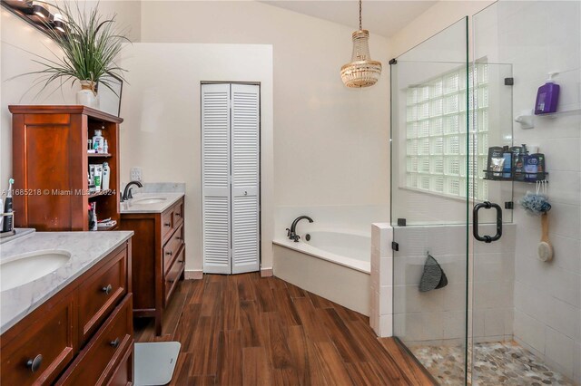 bathroom with hardwood / wood-style flooring, vanity, plus walk in shower, and lofted ceiling