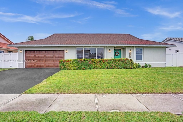 ranch-style home featuring a garage and a front lawn