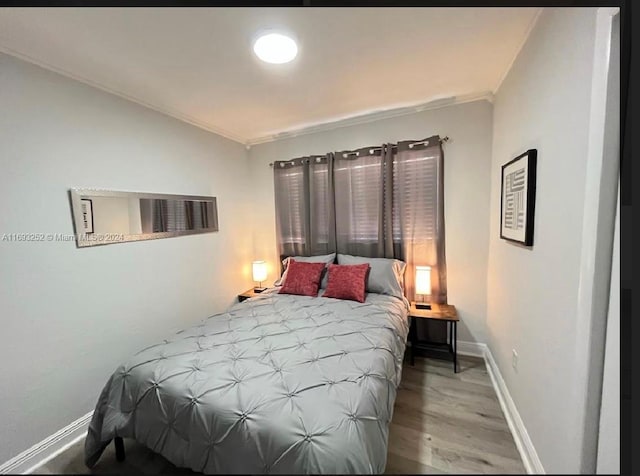 bedroom with light hardwood / wood-style floors and ornamental molding