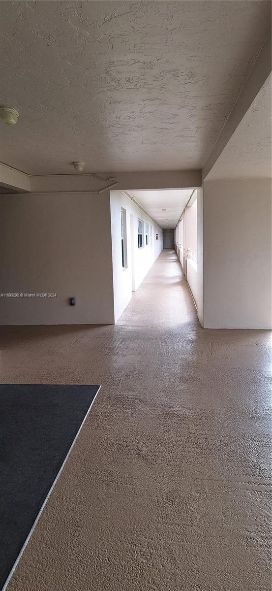 empty room with carpet flooring and a textured ceiling