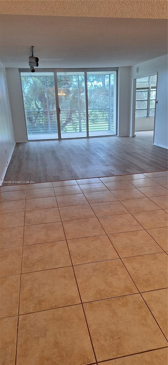 spare room with light hardwood / wood-style flooring and a textured ceiling