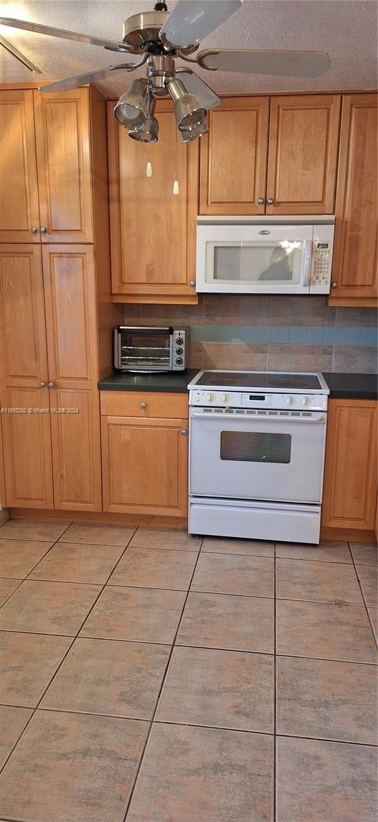 kitchen with a textured ceiling, decorative backsplash, ceiling fan, and white appliances