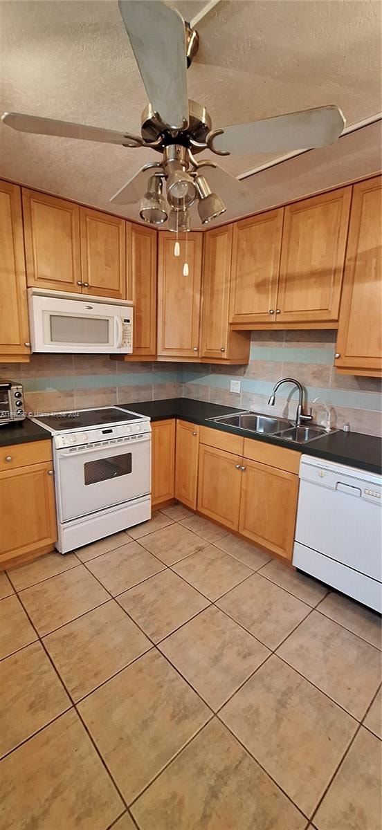 kitchen with white appliances, sink, ceiling fan, light tile patterned floors, and a textured ceiling