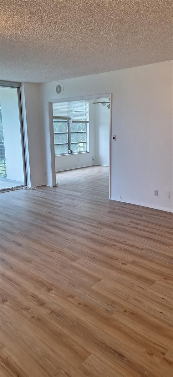 empty room featuring a textured ceiling and light hardwood / wood-style floors