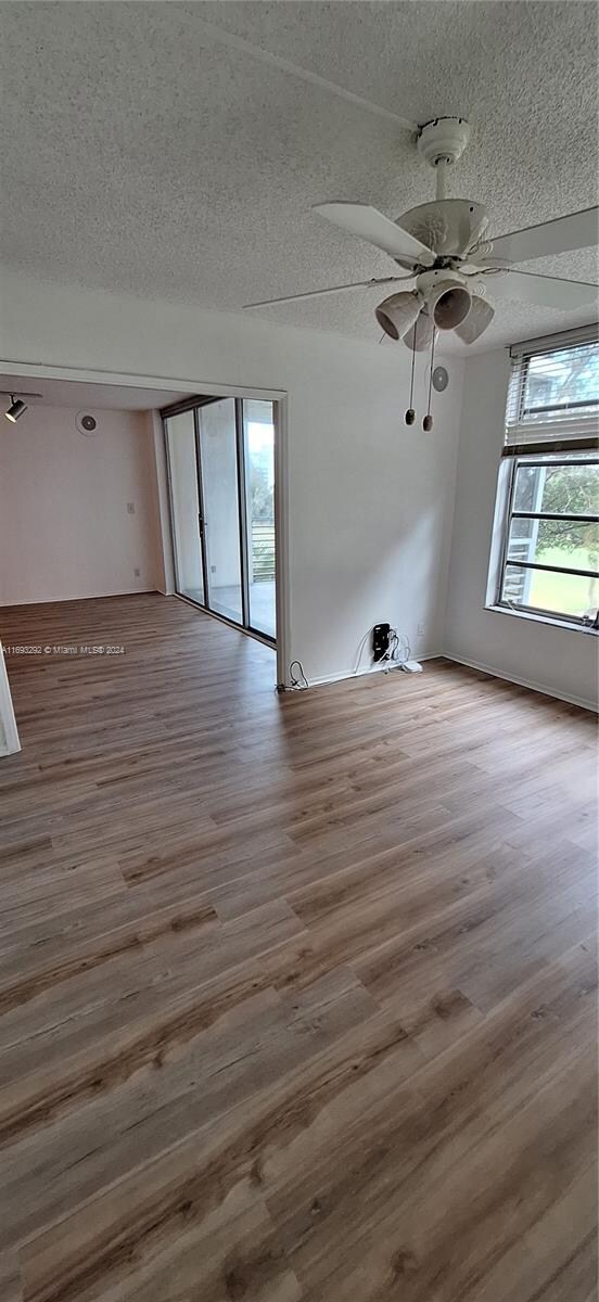 spare room with ceiling fan, wood-type flooring, and a textured ceiling