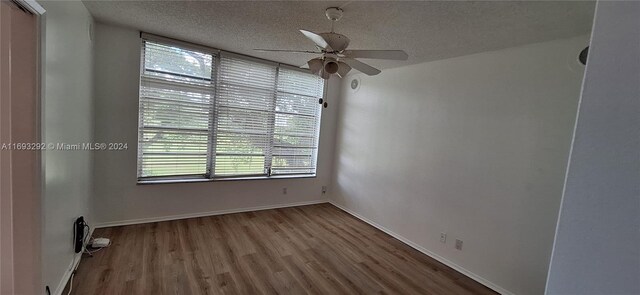 empty room featuring hardwood / wood-style floors, a textured ceiling, plenty of natural light, and ceiling fan