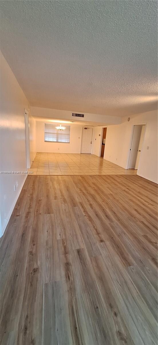 spare room featuring a textured ceiling and light wood-type flooring