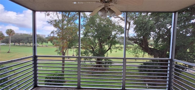 unfurnished sunroom with ceiling fan