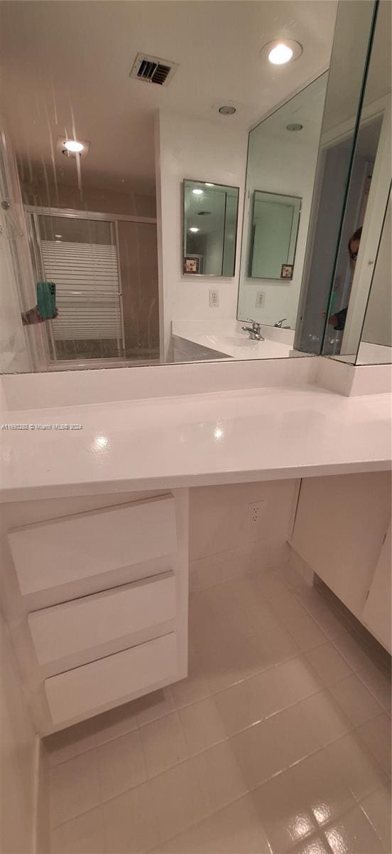 bathroom featuring tile patterned flooring, vanity, and a shower with door