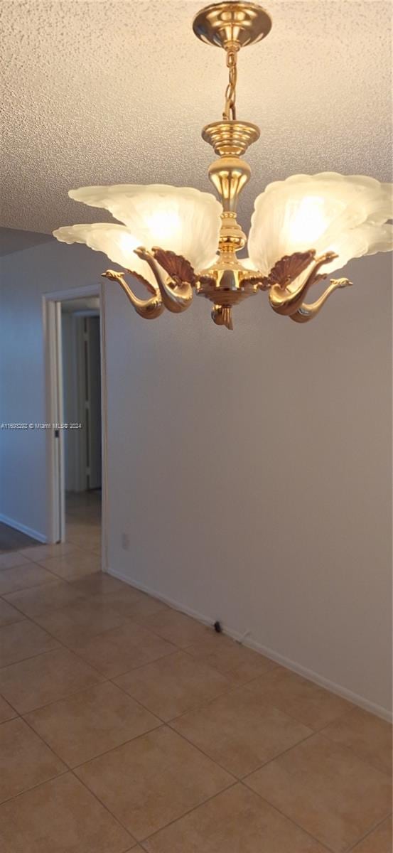 tiled empty room with a textured ceiling