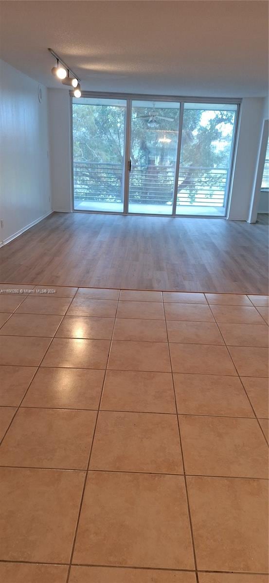 empty room featuring track lighting and light hardwood / wood-style flooring