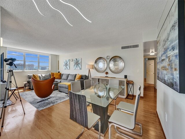 1833 S Ocean Dr Unit 1702, Hallandale Beach, FL 33009 - dining area with wood finished floors, a textured ceiling, and baseboards