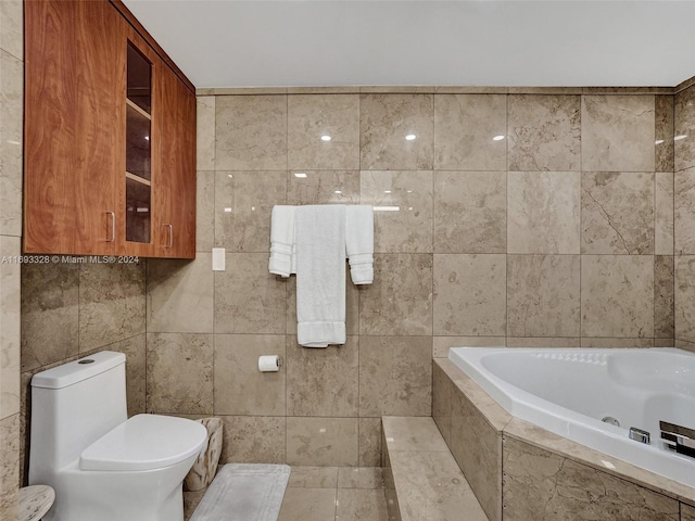 bathroom featuring tile walls, tile patterned flooring, tiled tub, and toilet