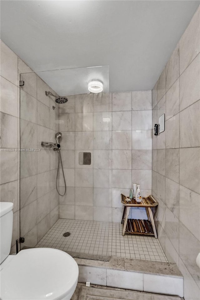 bathroom featuring toilet and a tile shower